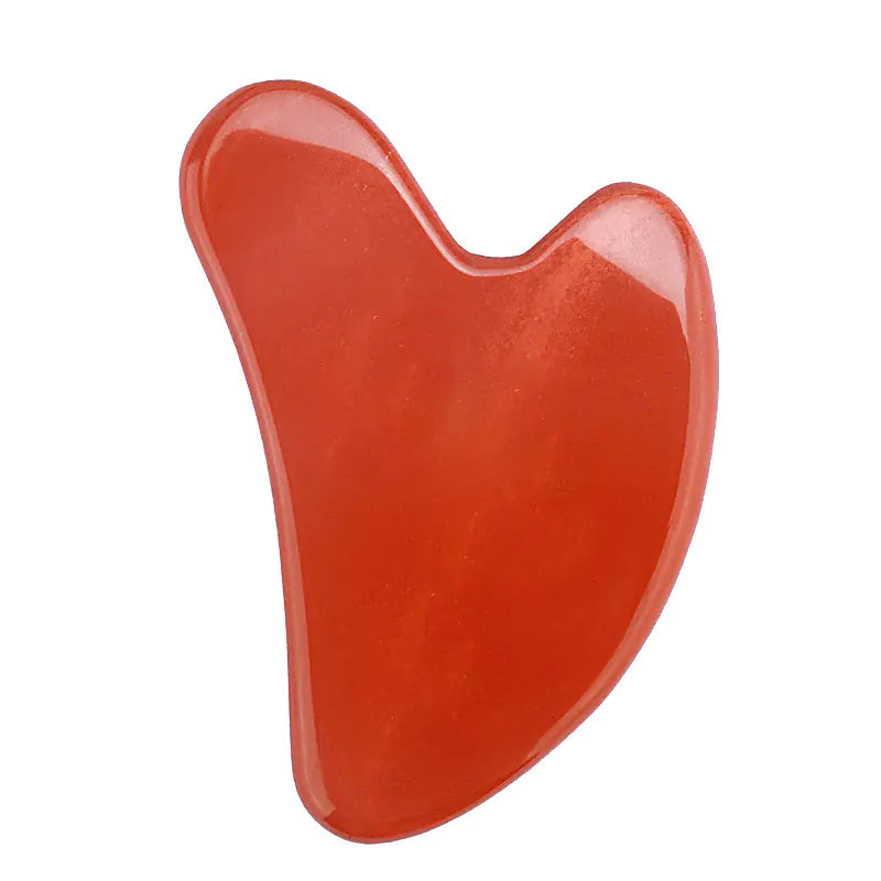 Red stone gua sha tool on a white background