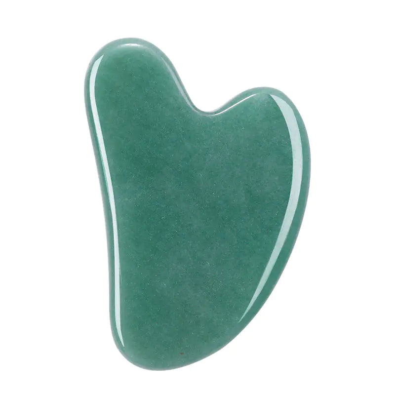 Green jade gua sha tool on a white background
