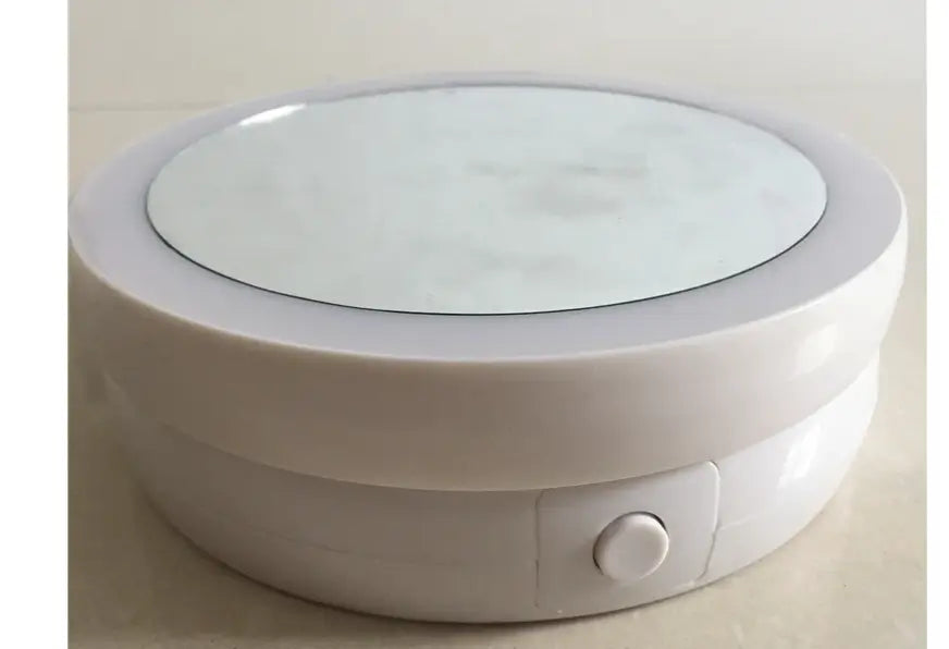 Round white electronic device with a glass top on a light background