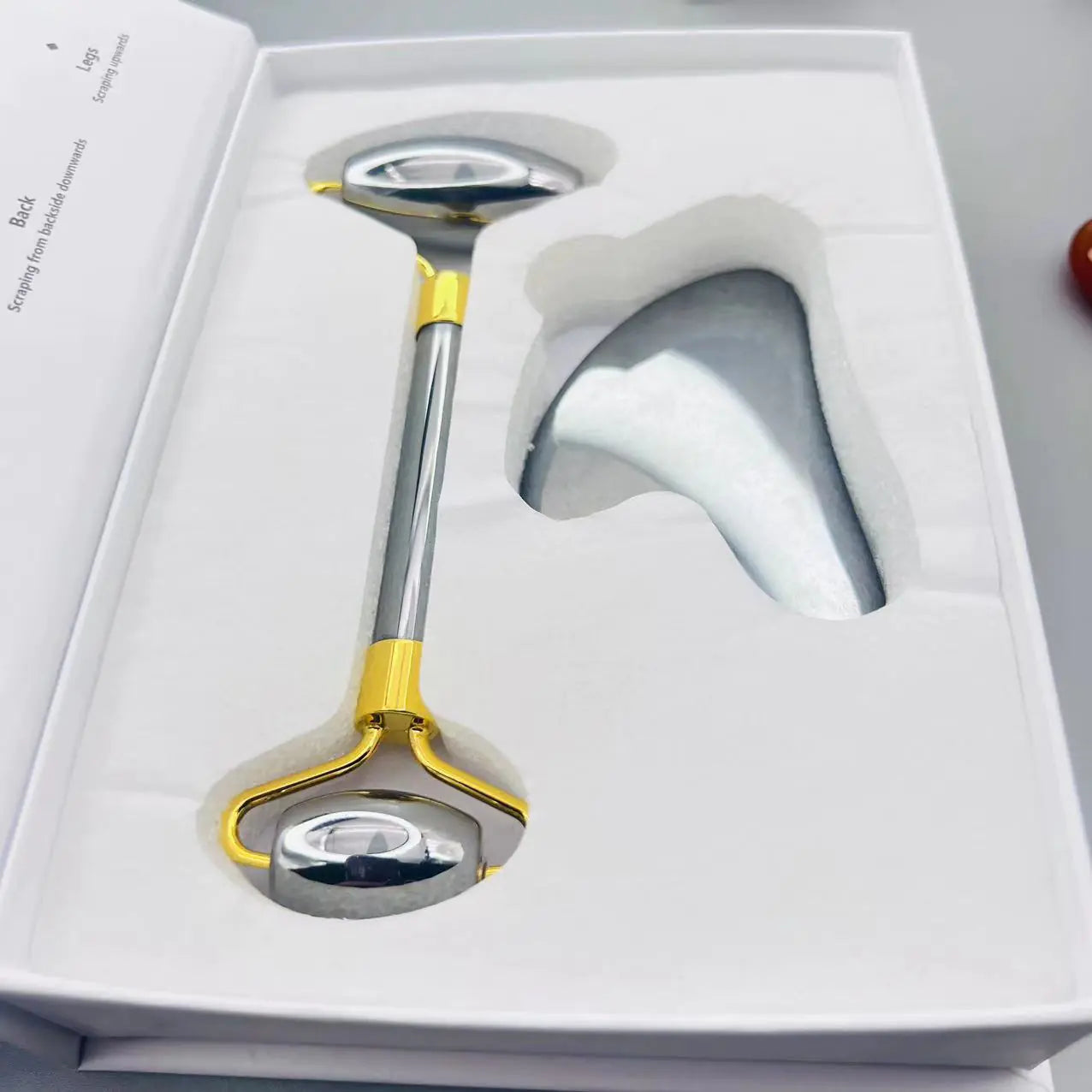 Metallic tool with yellow accents in a white box