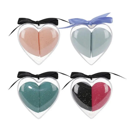 Four heart-shaped makeup products with bows on a white background