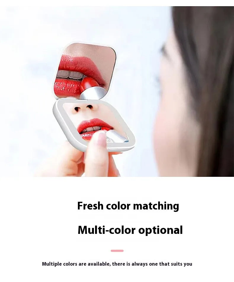 Portable mirror with a compact design, held by a hand, showing a close-up of lips with red lipstick.