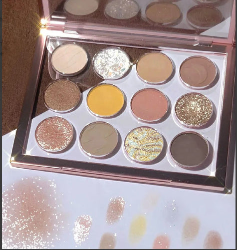 Makeup eyeshadow palette with various colors on a glittery surface