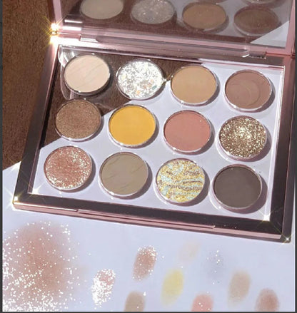 Makeup eyeshadow palette with various colors on a glittery surface