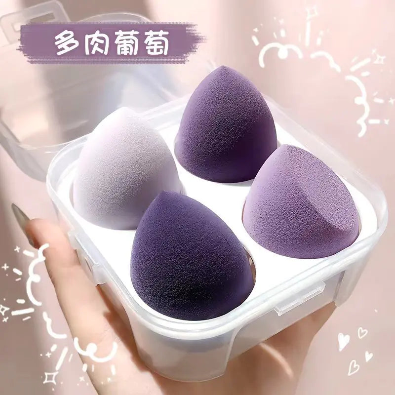 Four purple makeup sponges in a clear container held by a hand against a light pink background.