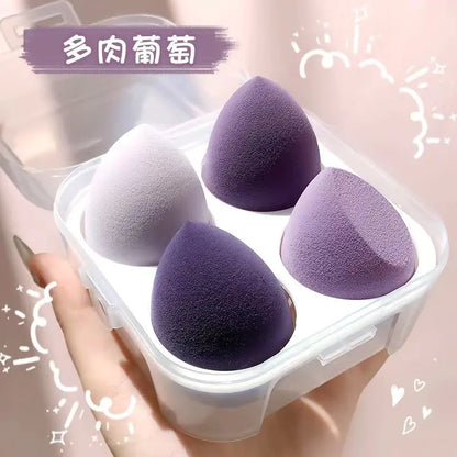 Four purple makeup sponges in a clear container held by a hand against a light pink background.