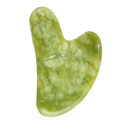 Green stone gua sha tool on a white background