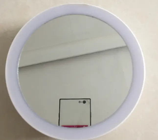Round mirror with a white frame on a beige wall