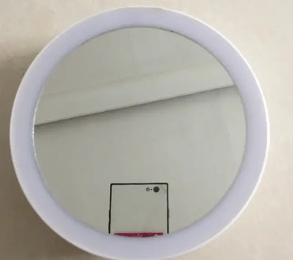 Round mirror with a white frame on a beige wall