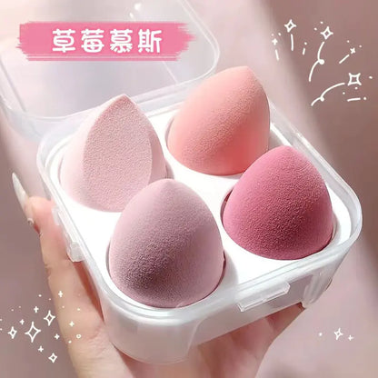 Pink makeup sponges in a clear container held by a hand on a pink background