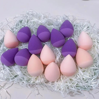 Set of purple and pink makeup sponges on a white background