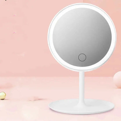 Round makeup mirror with LED lights on a pink background