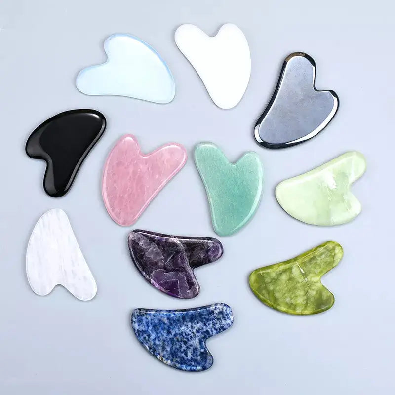 Collection of variously shaped and colored stone tools on a light gray background