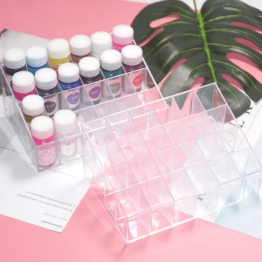 Set of small bottles with white caps on a pink surface with a green leaf in the background