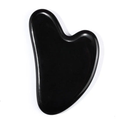 Obsidian gua sha tool on a white background