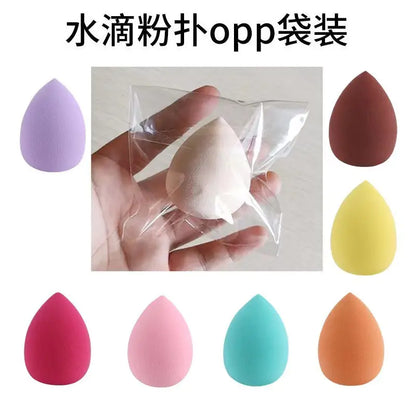 Makeup sponge in a clear bag held by a hand, with color options displayed below.