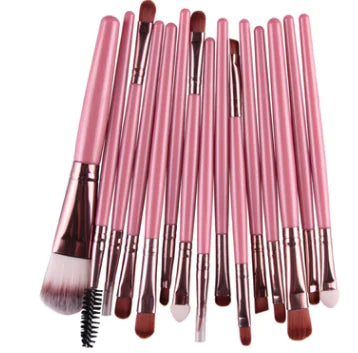 Set of pink makeup brushes on a white background