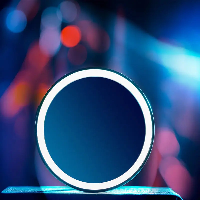 LED folding makeup mirror with a blue center and white rim on a blurred colorful background