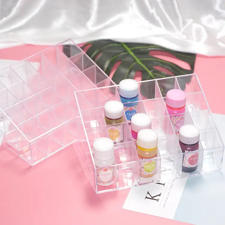 Clear acrylic organizer with small bottles on a pink surface