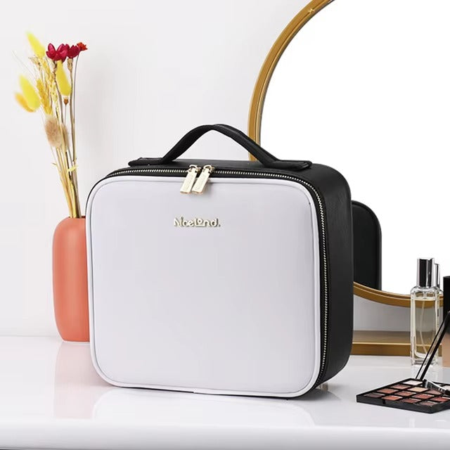 White and black cosmetic bag on a white surface with decorative items.