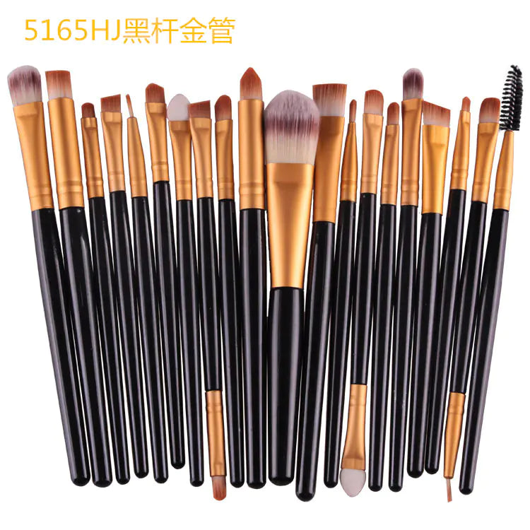 Set of makeup brushes with black and gold handles on a white background