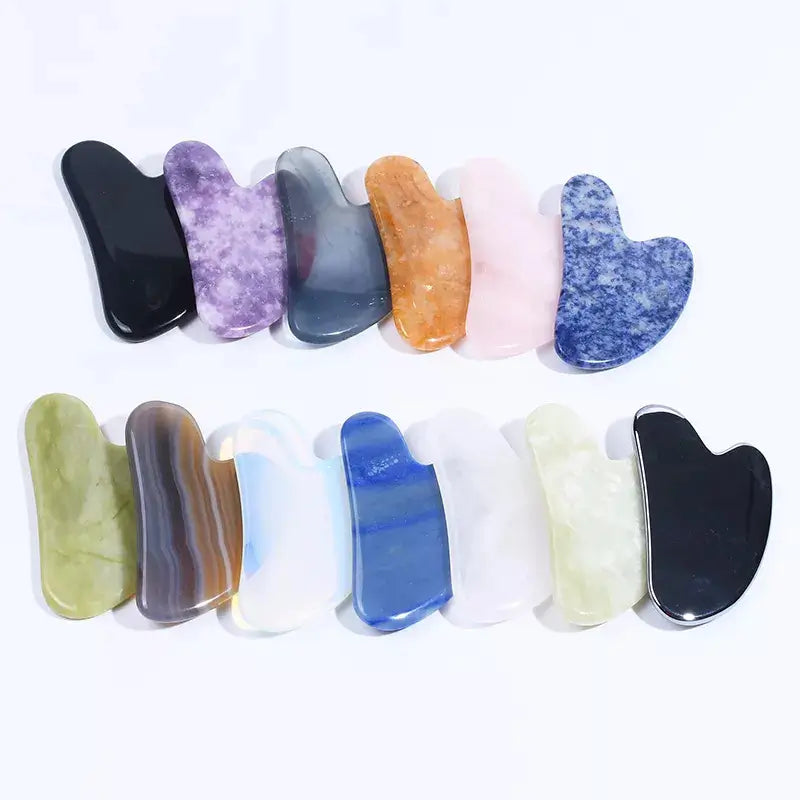 Set of colorful gua sha tools on a white background