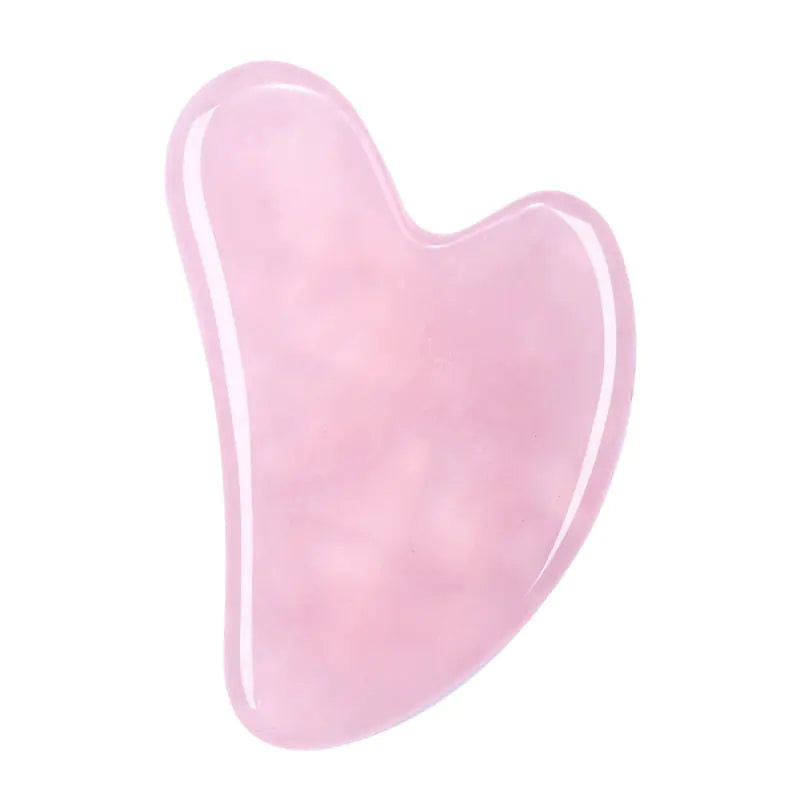 Pink gua sha tool on a white background