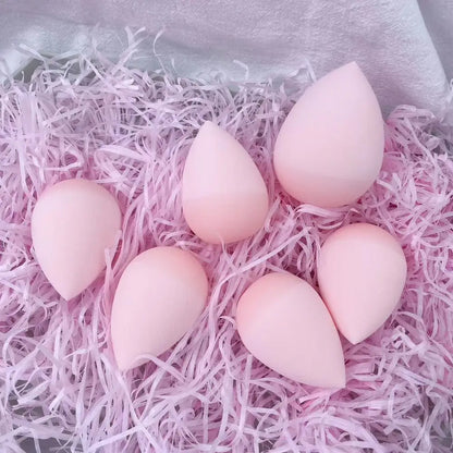 Pink makeup sponges on pink shredded paper