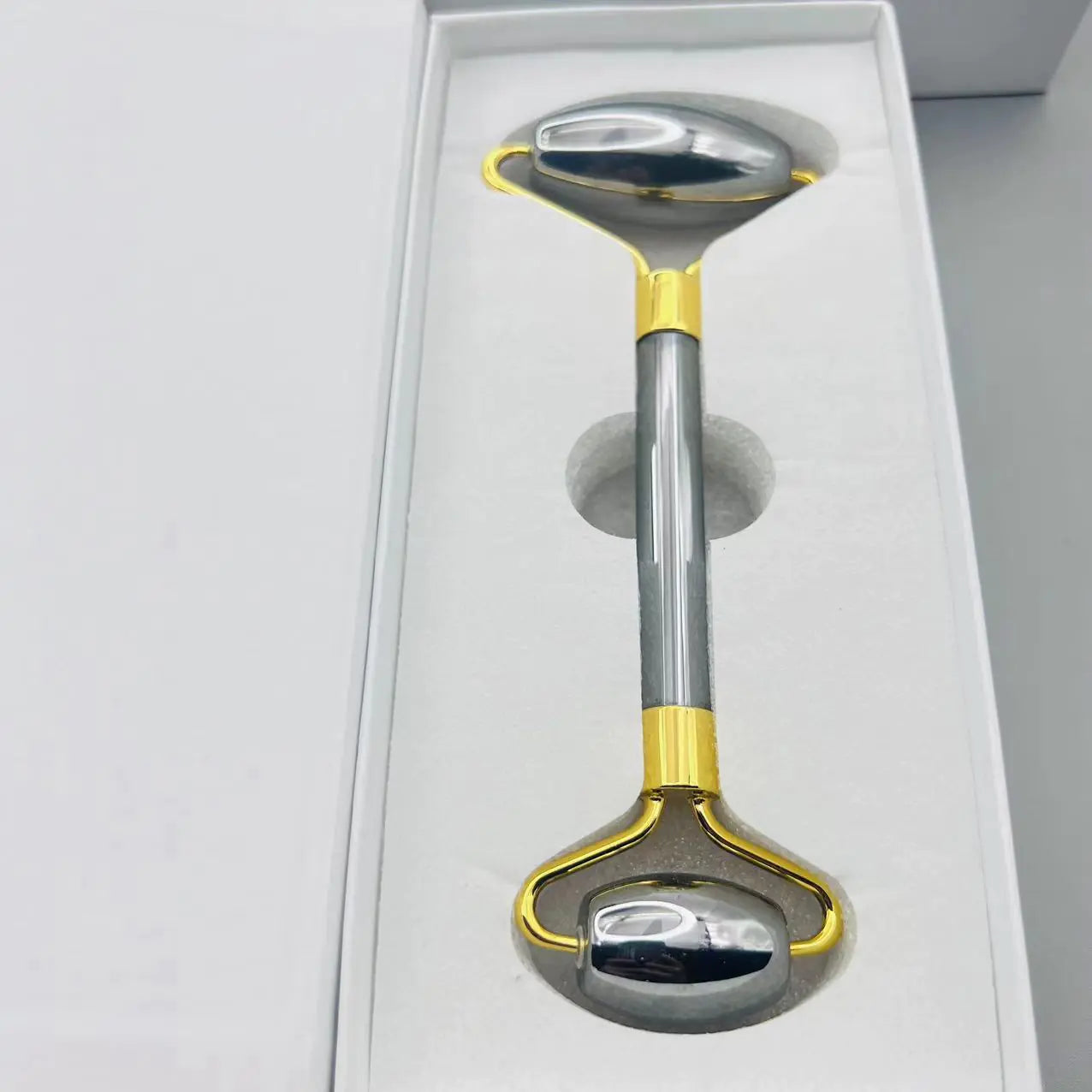 Metallic tool with gold accents on a white background