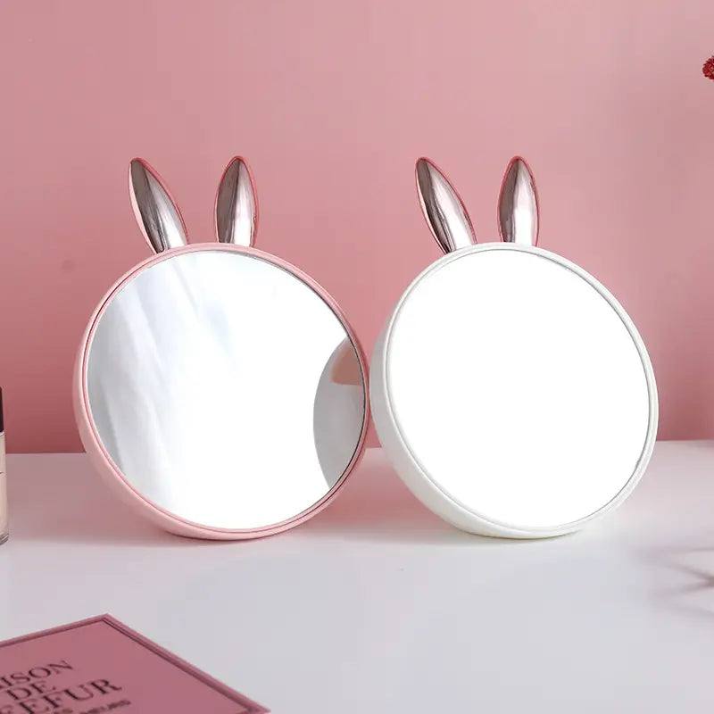 Two round mirrors with bunny ears on a pink background