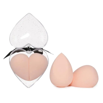 Heart-shaped makeup sponge with two additional sponges on a white background