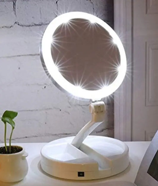 Lighted makeup mirror with a white base on a surface with a light gray wall background