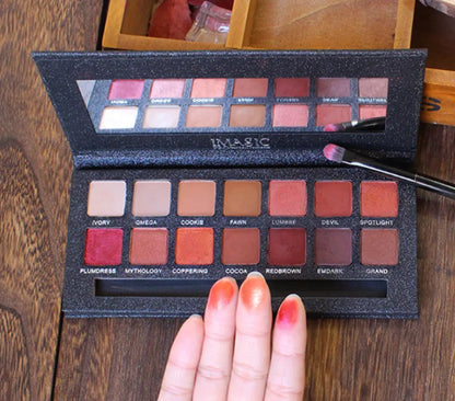 Makeup palette with various shades of eyeshadows on a wooden surface.