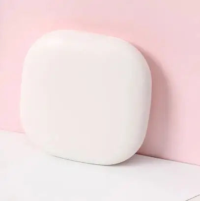 Round white compact LED mirror on a pink background