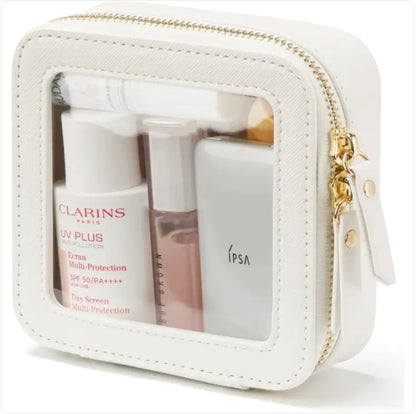 White cosmetic bag with skincare products including Clarins and Ipsa on a white background