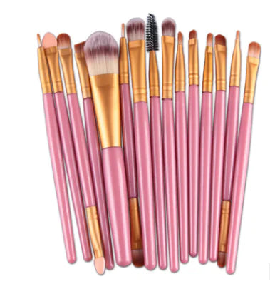 Set of makeup brushes with pink handles and gold accents on a white background